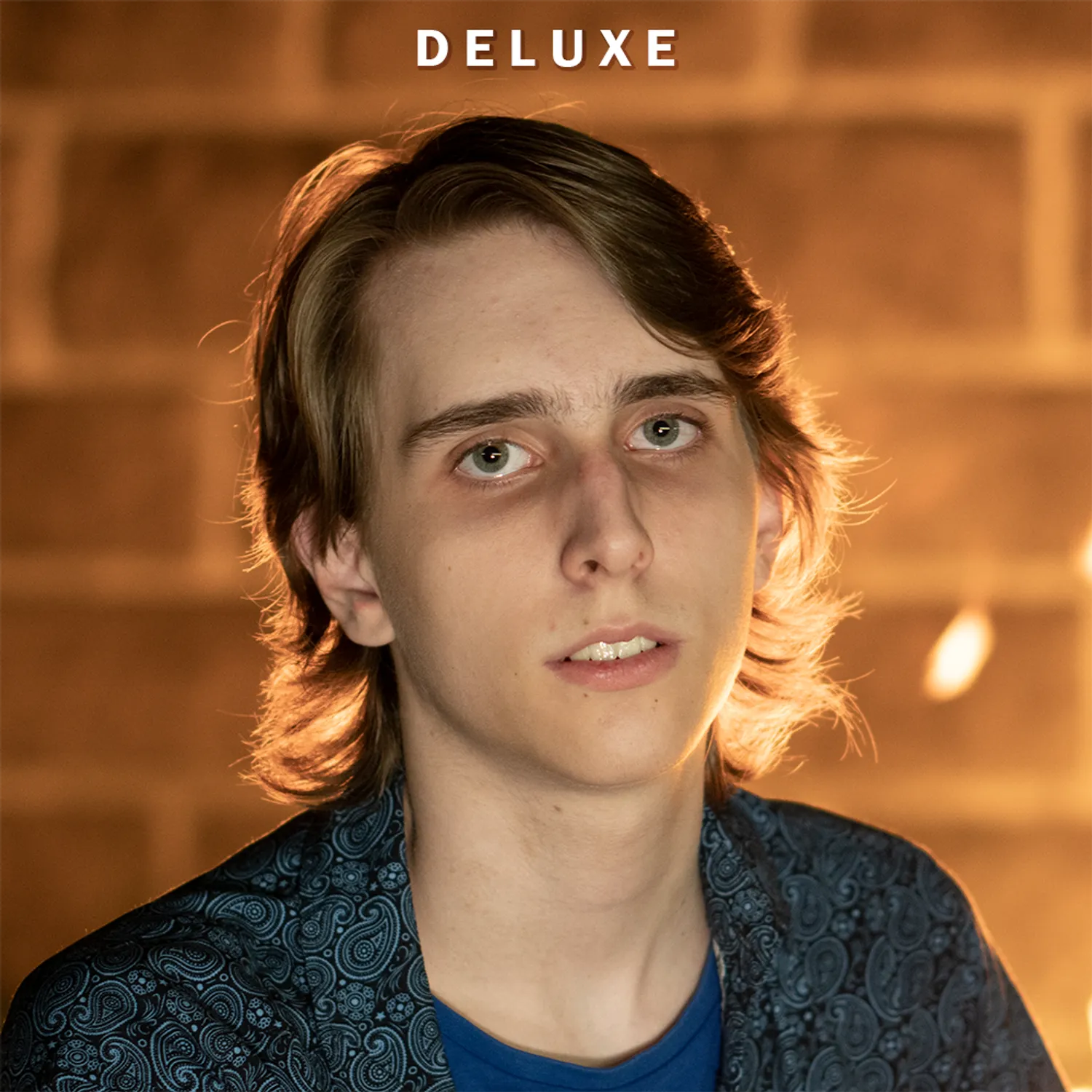 A picture of Misha Florian in front of a fire looking into the camera.